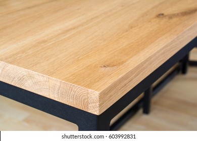 Edge And Corner Of Wooden Table Top Made Of Oak Wood. Table Top On Black Steel Frame. Shallow Depth Of Field.