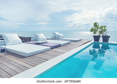 The edge Luxury swimming pool with white fashion deckchairs on the beach., Exterior design.