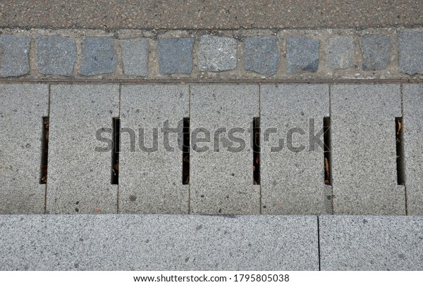 the edge of the road is drained by\
longitudinal channels of granite grids with gray slits at the\
deceleration retarder where the road goes uphill and downhill.\
light brown asphalt and\
cobblestones