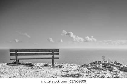 'Edge of the world' - Empty bench on top of a cliff, overlooking the sea in Malta