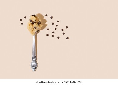 Edible Cookie Dough In Spoon With Chocolate Chips On The Yellow Background In Sunlight, Close Up.