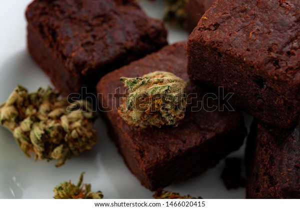 Edible marijuana for chronic pain\
treatment, alternative medicine diet and legal weed concept theme\
with close up on cannabis buds and delicious\
brownies