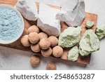 Edible various Clay Stones, clay rocks and powder on wooden background, top view.  Natural edible calcium chalk or clay, trendy snack.