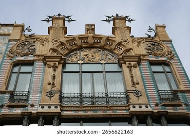 The Edificio El Águila was built in 1908 by the architect Gaspar Bennazar. The façade features balconies with corrugated iron railings, polychrome ceramics, and lush floral and plant decorations.