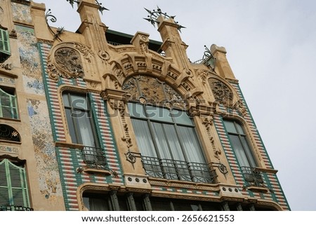 The Edificio El Águila was built in 1908 by the architect Gaspar Bennazar. The façade features balconies with corrugated iron railings, polychrome ceramics, and lush floral and plant decorations.