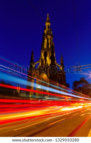 Edinburgh at night scene with Lights streak from high-sided vehicles on Princess street and Scott Monument on background