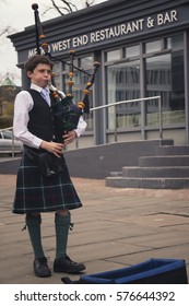 EDINBURGH, SCOTLAND - MARCH 13, 2016: A Young Boy Playing The Traditional Instrument Bagpipe In Edinburgh. He Wears The Kilt.