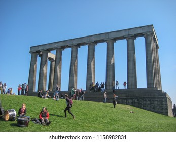 Edinburgh / Scotland / UK - 04/20/2014: View Of National Monument Of Scotland, On Calton Hill In Edinburgh, With Grass Around And People Enjoying It