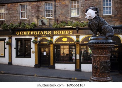 Edinburgh, Scotland / United Kingdom - 03 22 2020:
The face of Greyfriars Bobby's dog  covered with a respiratory mask during the COVID-19 pandemic.