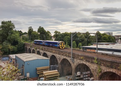 Edinburgh, Scotland / United Kingdom - August 4 2018: A Scotrail Train British Rail DMU Class 158 Express Sprinter Is Travelling At Speed Over An Old Stone Bridge In Edinburgh.