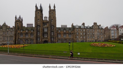 Edinburgh / UK - Circa April 2015: Woman Running Down The Street In Front Of Green Park With Old Buildings In Background In A Cloudy Afternoon.