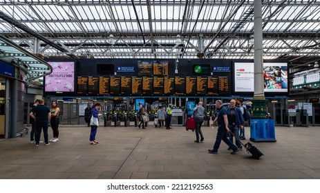 EDINBURGH, UK - JUNE, 2022: Passengers Waiting At Train Terminal Under Train Timetable Notice Boards In Edinburgh Waverley Train Station.