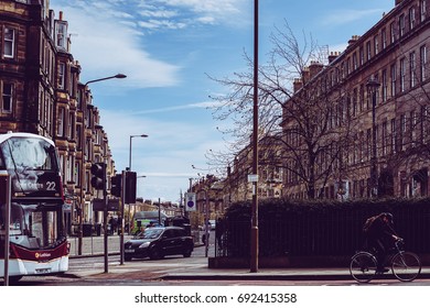 Edinburgh, United Kingdom. April 13, 2017. The Bus And The Car Driving And The Man Cycling On The Elm Row Road, Edinburgh, Scotland, United Kingdom