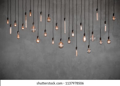 Edison retro lamp Incandescent bulbs on gray plaster wall background in loft. Concept Vintage style. Copy space
