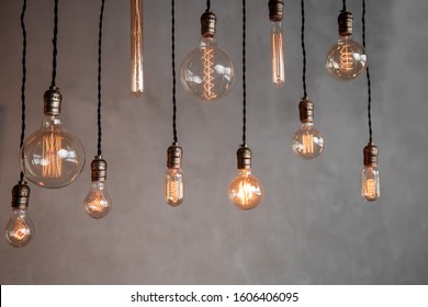 Edison retro lamp incandescent bulbs on gray plaster wall background in loft. Concept Vintage style. Copy space. - Powered by Shutterstock