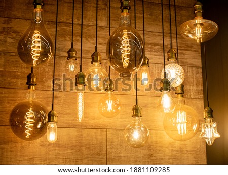Edison vintage lamps in a glass flask with a tungsten thread inside on a dark background for a modern interior in the house. Assortment in the store. Warm light.