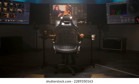 The editor works in studio on computer, edits video, makes color correction for movie post production. Big screens showing color grading program interface with film footage, RGB graphic and levels. - Shutterstock ID 2289350163