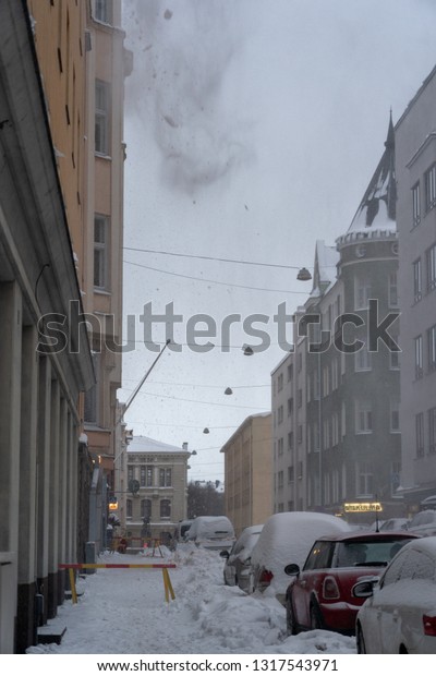 Editorial 02.02.2019 Helsinki Finland, Snow is\
being dropped down from the roof of a building by roof workers for\
safety reasons