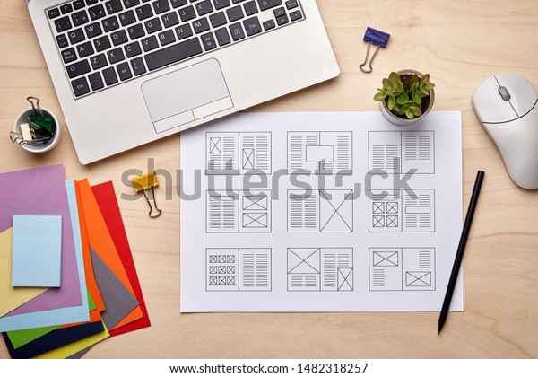 Editorial design. Graphic designer desk with magazine\
layout designs. Flat\
lay