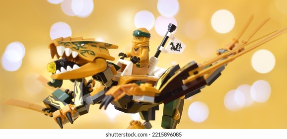 Editorial Illustrative Image Of Lego Ninjago Minifugure Lloyd Green Ninja On Gold Dragon With Sword Weapon On Defocused Background