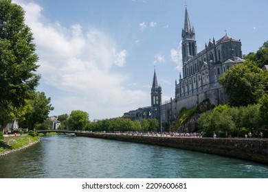 Editorial. July, 2022. Lourdes, France. View Of The River Gave De Pau And The Basilica Of The Holy Rosary In Lourdes, France. The Sanctuary At Lourdes.