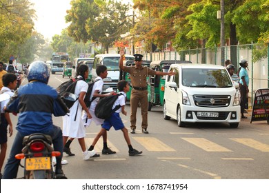 Editorial Traffic Cop Policeman Pedestrian Crossing. Children Go To School In The Morning In White Clothes. Transport On The Road. Sri Lanka, Negombo, 2020.