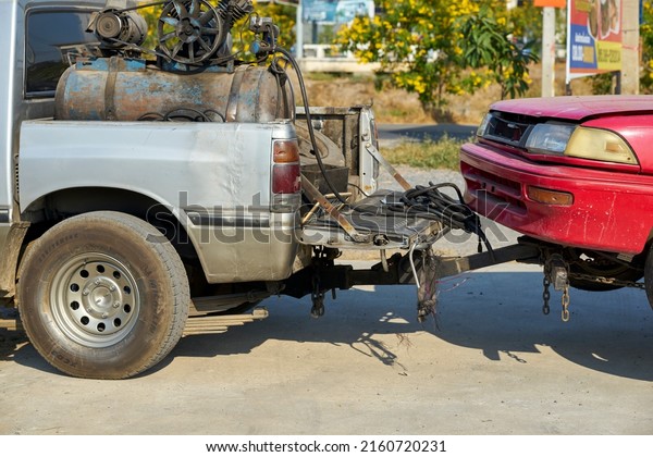 Editorial use\
only; a car being towed by a pickup truck, taken at Pathumthani,\
Thailand in January\
2019.