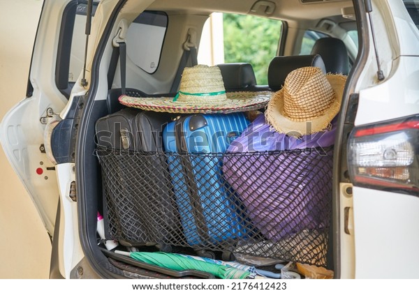 Editorial use only; a car packed for summer vacation
with suitcases and straw hats, taken at Pathumthani, Thailand, in
June 2022.                   
