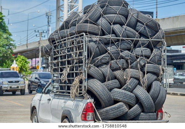Editorial use only; old used car tires being\
transported on an overloaded truck, taken at Pathumthani, Thailand,\
in June 2020.
