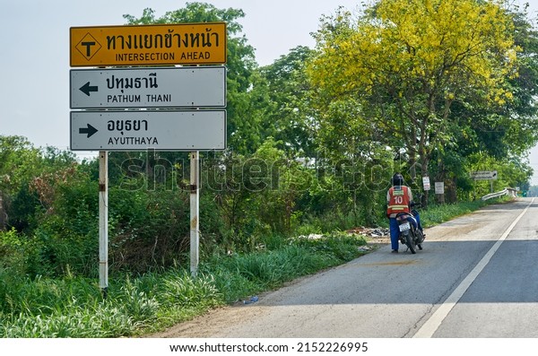 Editorial use\
only; road signs with directional arrows, on a road, taken at\
Pathumthani, Thailand, in May 2022.    \
