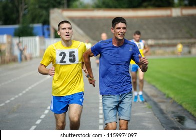 Editorial use only. Runner leading disabled blind athlete (left) by strapped hands. Trials among disabled Ukrainian soldiers to the 43 rd US Marine Corps marathon. July 20, 2018. Kiev, Ukraine