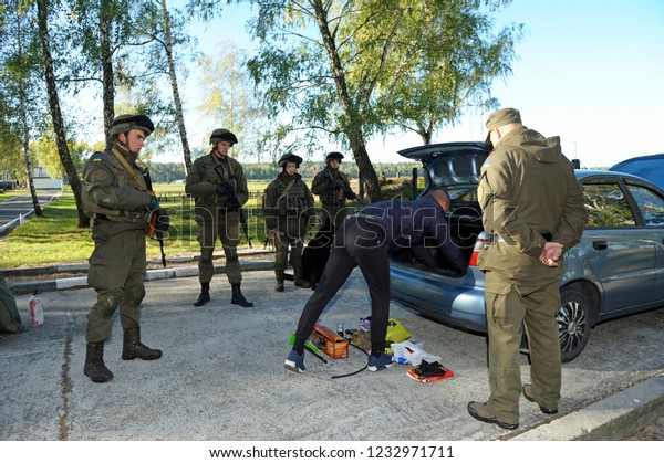 Editorial use only. Search at the checkpoint,\
training. Man pulls his personal belongings out from a car,\
soldiers stand around watching. October 18, 2018. Novo-Petrivtsi\
military base,\
Ukraine