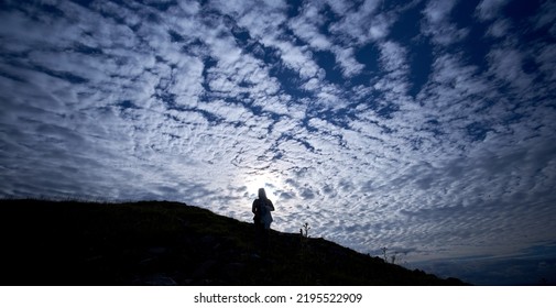 Editorial Use Only; A Silhouette Of A Lady On A Hill, Under An Evening Sunset Sky With Many White Clouds, Taken In Longford, Ireland In July 2017.             