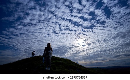 Editorial Use Only; A Silhouette Of A Lady On A Hill, Under An Evening Sunset Sky With Many White Clouds, Taken In Longford, Ireland In July 2017.             