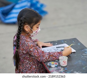 Editorial Use Only; A Small Girl Wearing A Face Mask While Drawing And Painting At An Outdoor Market, Taken At Pathumthani, Thailand, In December 2021.      