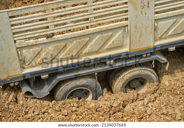 Editorial use only; a truck with its wheels stuck in the
mud at a construction site, taken at Pathumthani, Thailand, in
March 2022.   