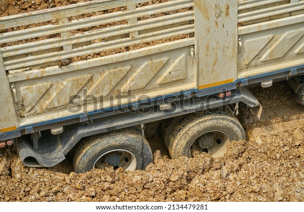 Editorial use only; a truck with its wheels stuck in the\
mud at a construction site, taken at Pathumthani, Thailand, in\
March 2022.   