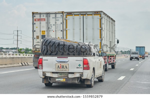 Editorial use only; a very large tractor\
tire, being transported in the back of a pickup truck, taken\
outside Bangkok, Thailand, in November 2019.     \
