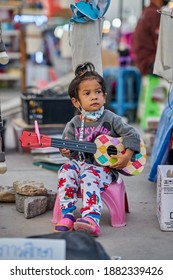 Editorial Use Only; A Young Child Busker Wearing A Face Mask, At A Local Night Market, Taken At Pathumthani, Thailand, On December 25th, 2020.           