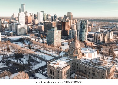 Edmonton, Alberta - December 05, 2020: Winter aerial view of the legislature in Edmonton, Alberta, at sunrise. It's a blue sky day with snow covering the ground, downtown can be seen in the background