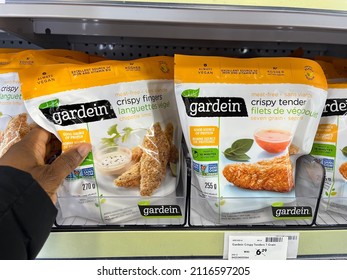 Edmonton, Canada - January 15, 2022: Black Person Reaching For Bags Of Gardein Meat-free Seven Grain Crispy Tenders And Chipotle Lime Crispy Fingers On Display On A Grocery Store Shelf