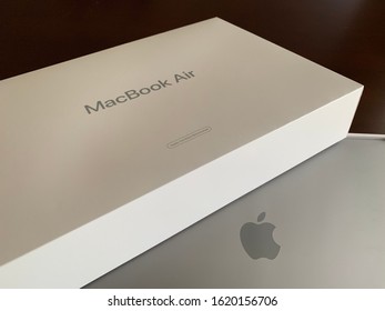 Edmonton, Canada - January 19, 2020: A Top View Of An Apple MacBook Air Certified Refurbished Laptop And Its Box Against A Dark Background  