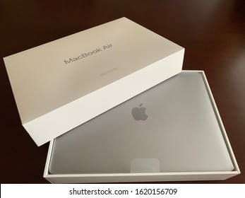 Edmonton, Canada - January 19, 2020: A Top View Of An Apple MacBook Air Certified Refurbished Laptop And Its Box Against A Dark Background  