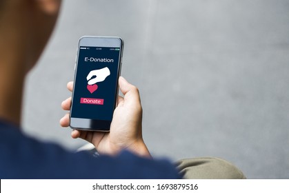 e-donation concept.close-up of man hands make an online donate via mobile phone - Shutterstock ID 1693879516