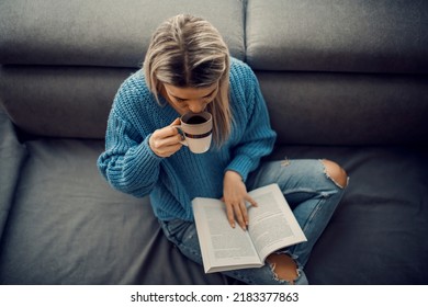 An Educated Woman Sipping Coffee While Reading An Interesting Book At Home.