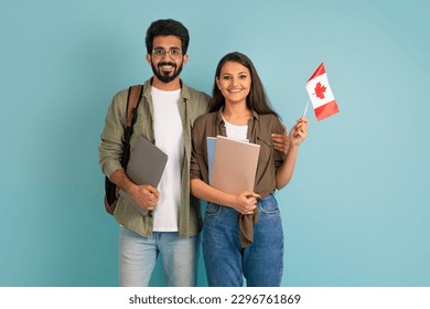 Education abroad, immigration to EU, language school. Cheerful multicultural young arab man and indian woman students with Canadian flag, books and laptop on blue background - Powered by Shutterstock