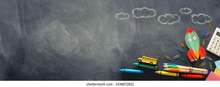 education. Back to school concept. rocket cut from paper and painted over blackboard background. top view, flat lay. banner