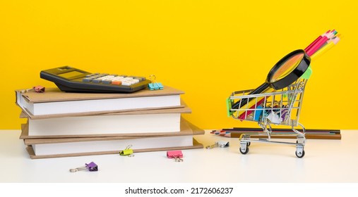 Education, Back To School. Shopping Cart With Supplies Near Pile Of Books.