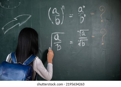 Education. Back View Of School Girl On Science Lesson In Classroom Write An Answer On Blackboard, Primary Child Is Standing In Front Of Class In School Writing Chalkboard, Back To School Concept