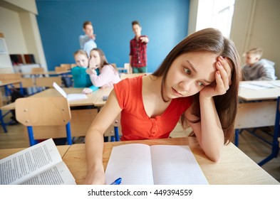 education, bullying, conflict, social relations and people concept - students teasing and judging girl classmate behind her back at school - Powered by Shutterstock